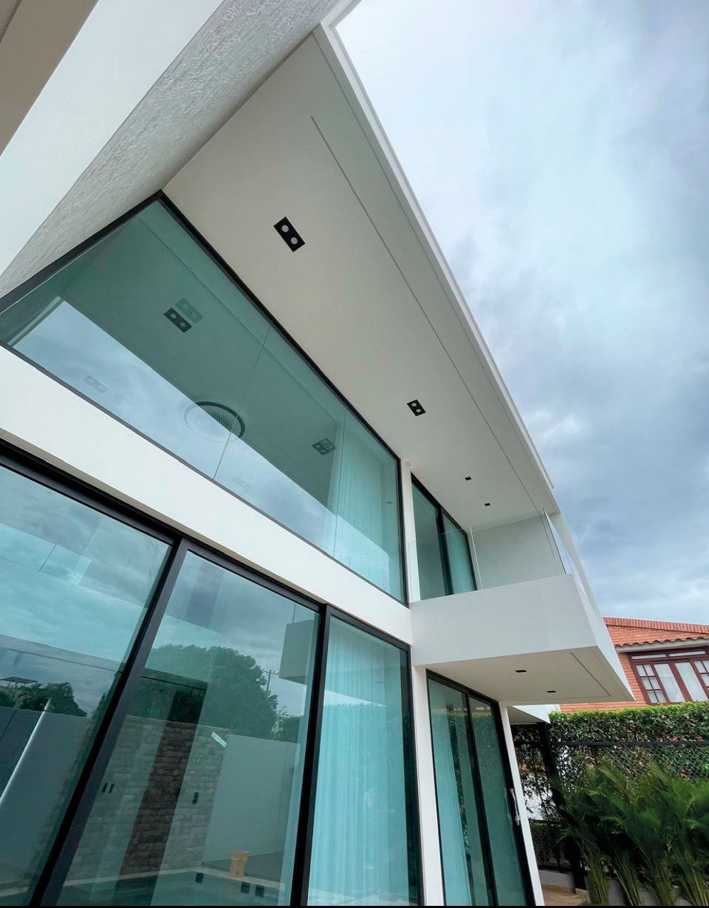 Esquina de casa moderna con ventanería de piso a techo