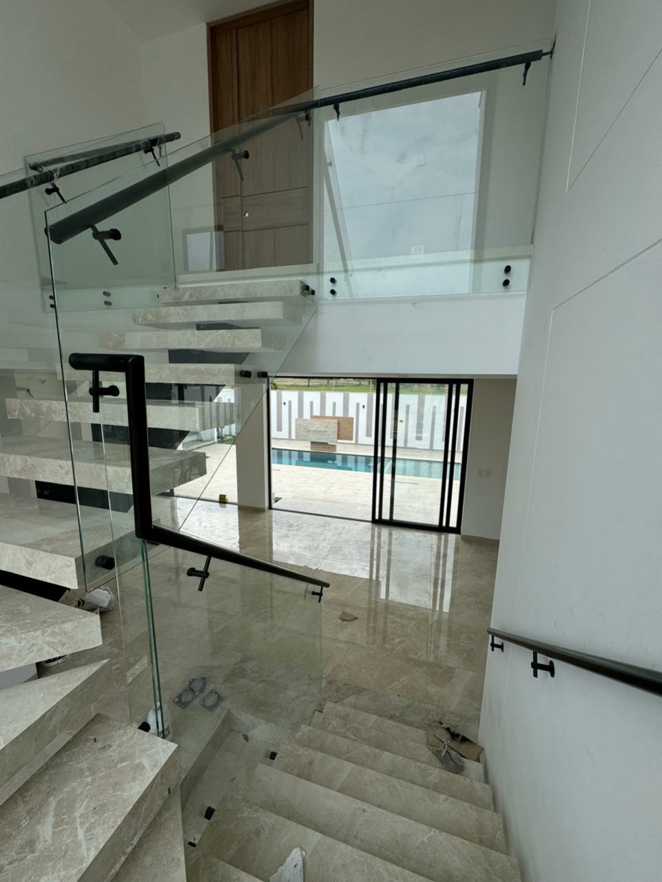 Escalera en mármol con baranda de vidrio templado